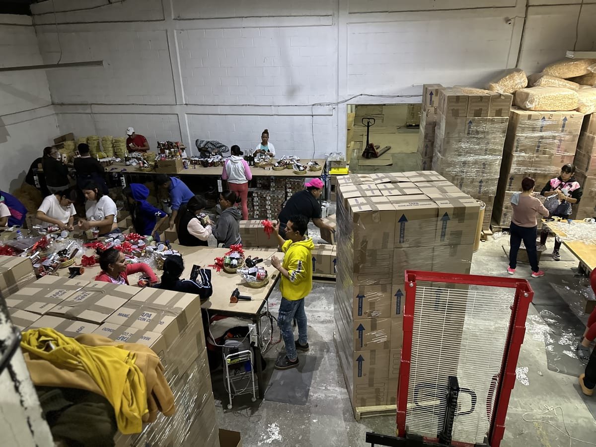 Equipo de producción de Canastas Navideñas México armando y empacando canastas navideñas en el almacén